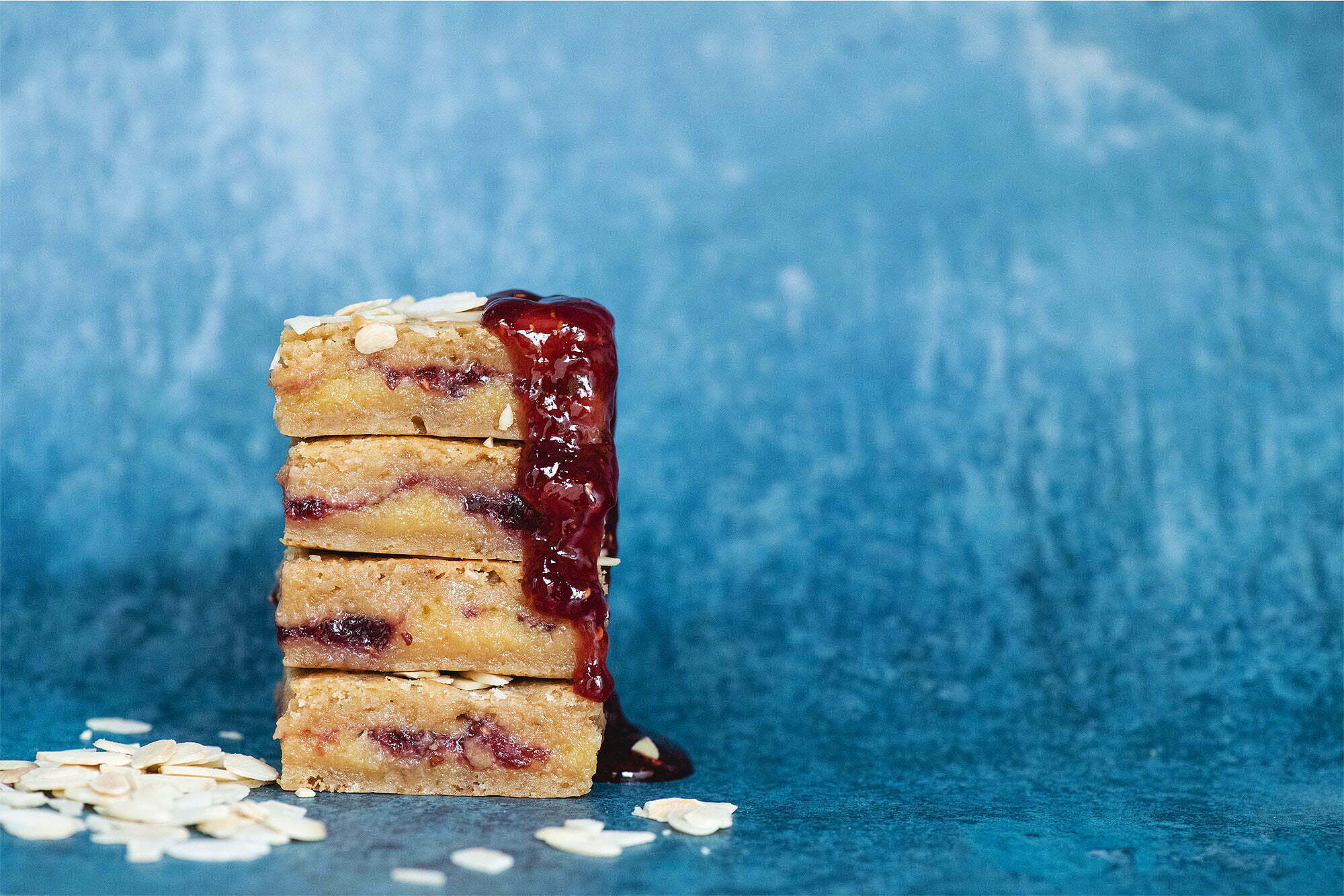 Best selling Blakewell flavour stacked with jam drizzling on a blue background