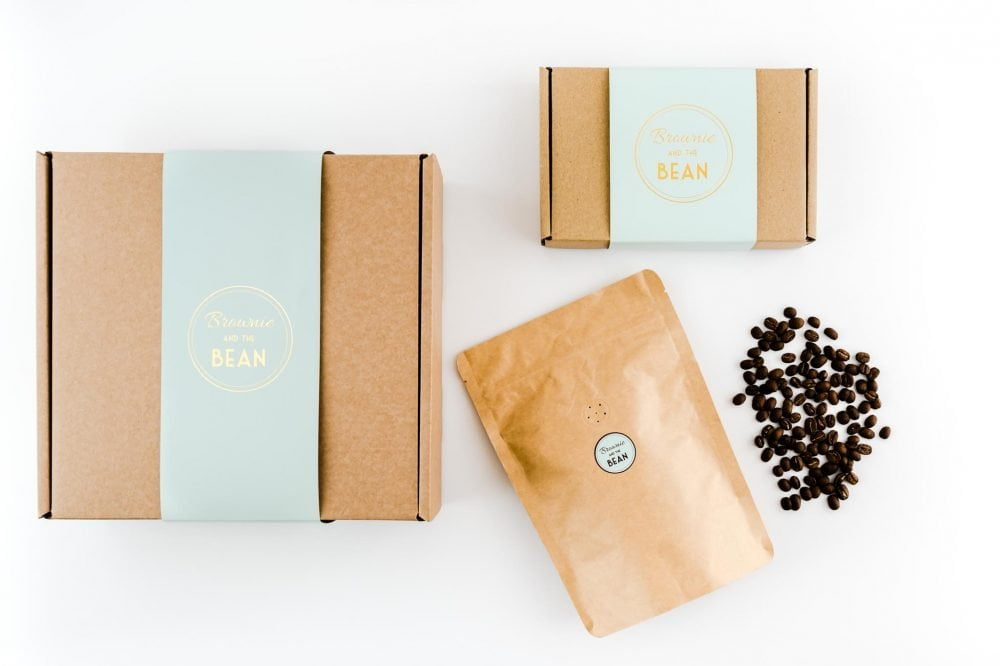 Gift boxes containing brownies, a Coffee pouch and whole coffee beans on a white background.