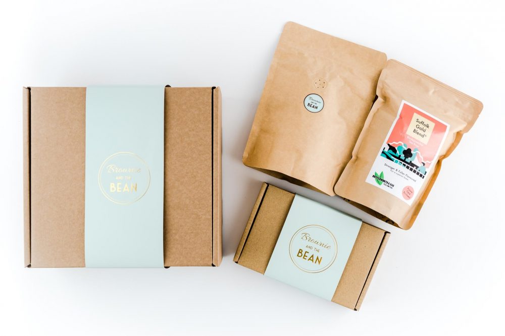 Brownie and The Bean's Tea and Coffee Brownie gift set. There is a medium sized branded gift box and a small sized branded gift box. Placed next to the boxes is two large packets of Butterworth and Son's tea and coffee. All products are placed on a white background.