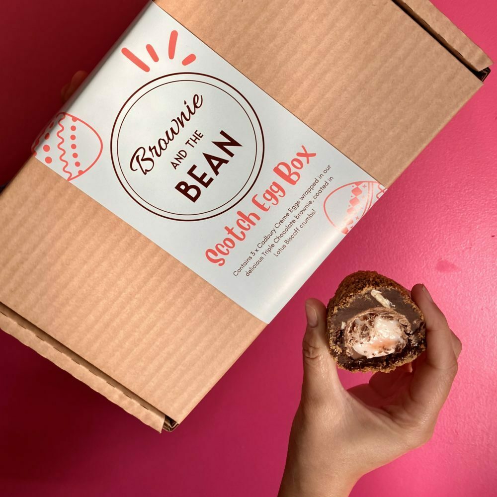 Scotch Egg Easter Brownie half against a pink background with a gift box.