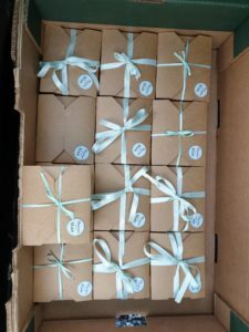 lots and lots of boxes of brownies ready for delivery. Wrapped beautifully with mint green ribbon. There is also a branded sticker on the boxes.