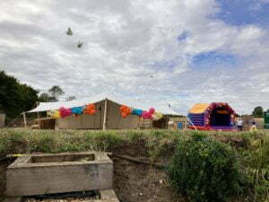 Tents and a bouncy castle in a field. Brownie and the Bean attended this party with their dessert catering.