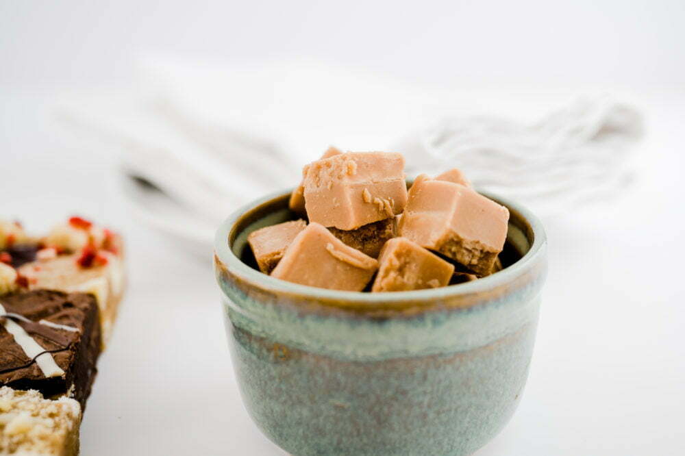 a pile of fudge in a pot with napkins in the background on a white backdrop.