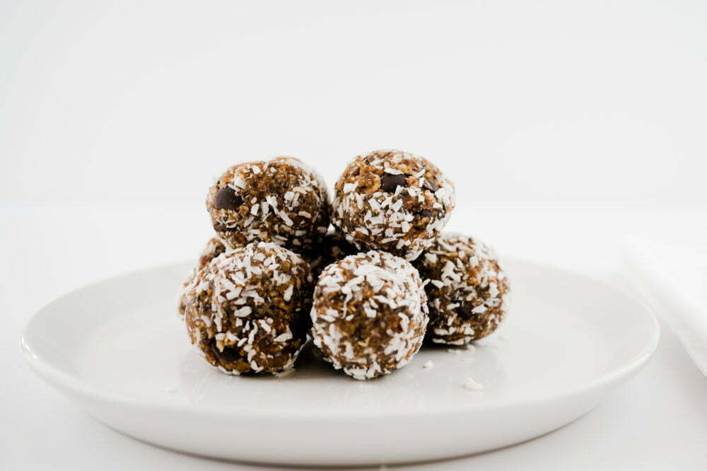 Our Power Ball vegan treats are piled on a round sides-late with a white background.