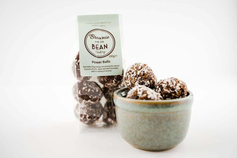Our Power Ball Vegan Treats in a bowl with a packet of vegan treats in the background