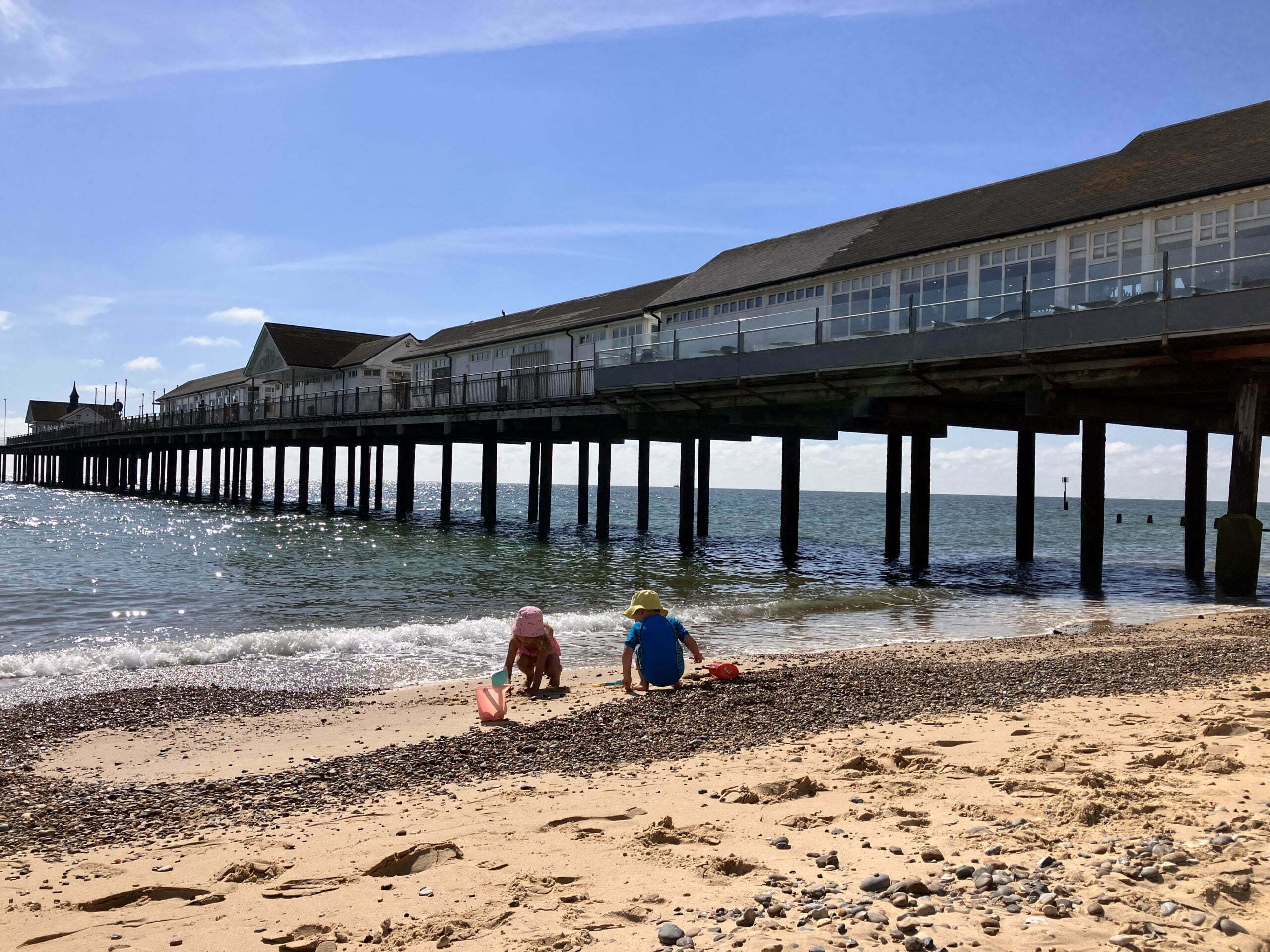 two children playing next to a pier on a beach. This was the result of taking a detour from a wholesale cake delivery in the summer holidays.