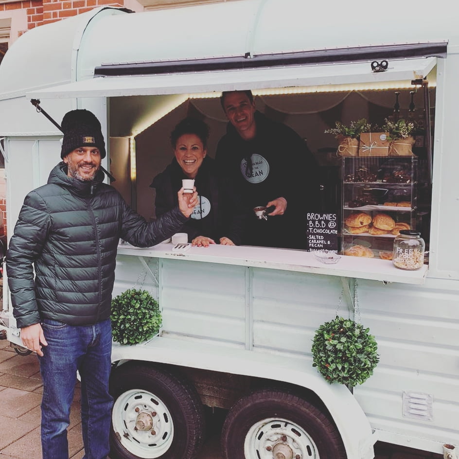 Charlotte and Luke are in their mint green horse trailer, stood behind the counter. In the forefront is Butterworth and Son's owner, Rob Butterworth.