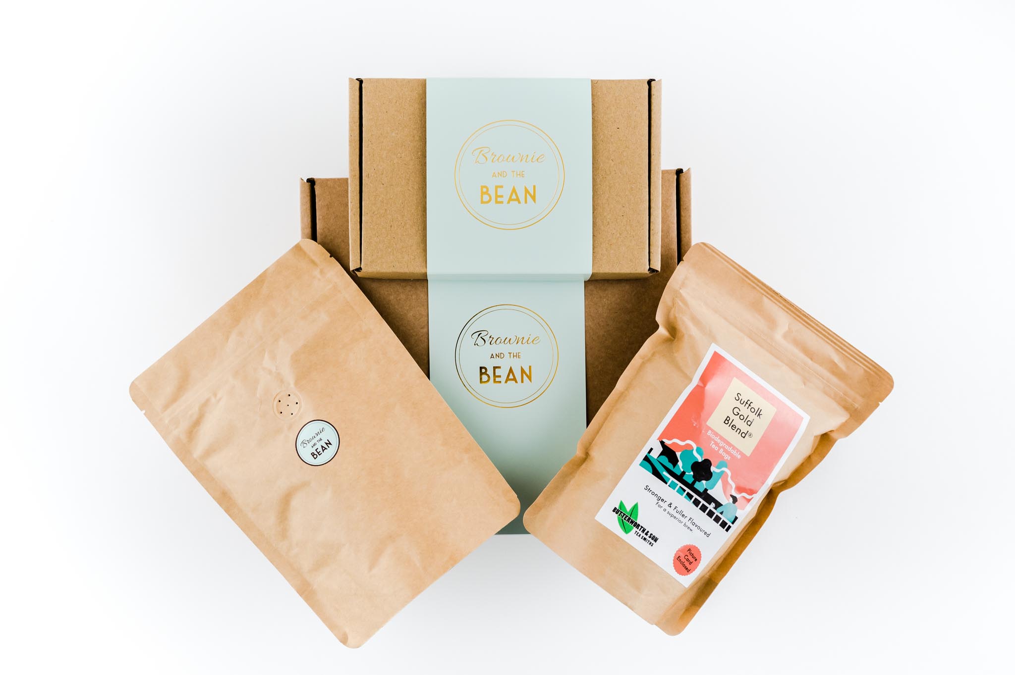 packshot features the best new baby gift ideas. There are two Brownie and the bean boxes on top of one another and a pouch of artisan coffee and tea is fanned out across the top of the shot.