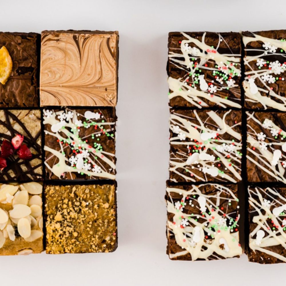 A close up of our 50/50 Christmas brownie box. On the left is our Christmas Mixed Brownie Box and on the right is our Christmas Triple Chocolate Brownie Box.